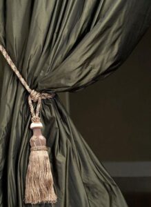 Dark moss green silk curtain held back by a silver bronze tie back. Use this to create Georgian style interiors.
